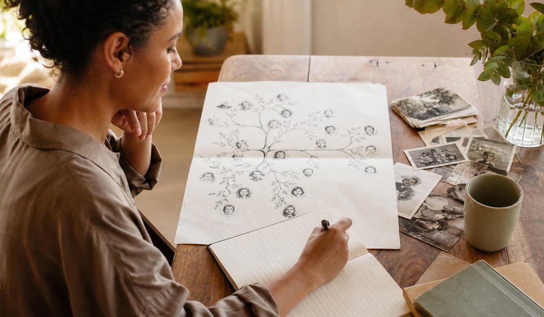 Adult reviewing a multigenerational family tree and writing new boundaries in a journal